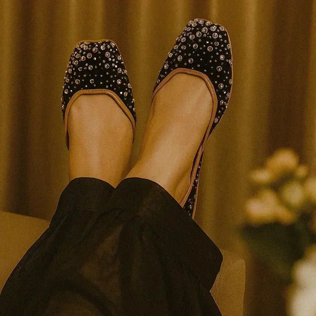 Black embellished juttis with crystal details, perfect for elegant occasions and romantic styles.