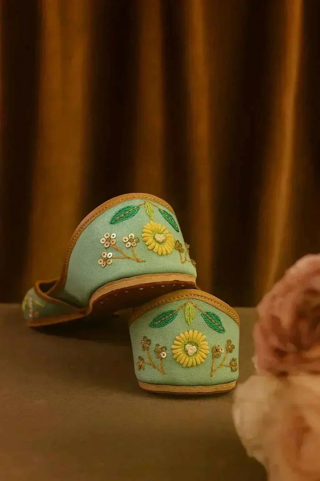 Handcrafted mint green juttis with floral embroidery and sequins, perfect for romantic, elegant styles.