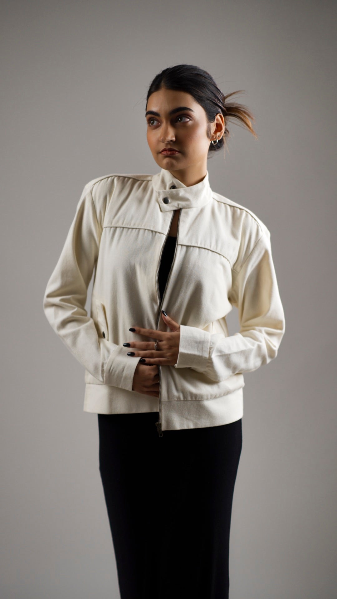 Woman wearing a white coloured cotton canvas jacket over a dark skirt