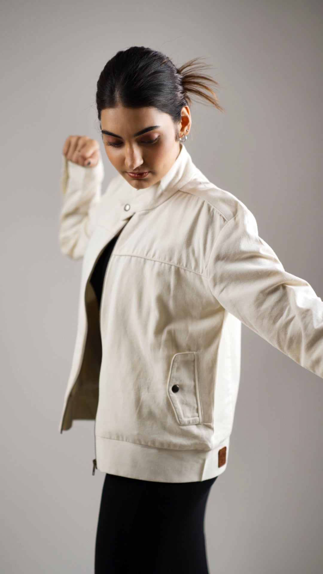 Woman wearing a white coloured cotton canvas jacket over a dark skirt